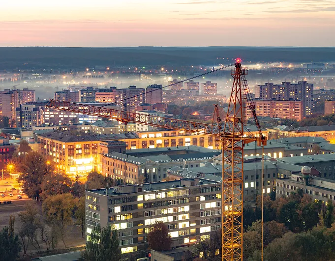 A growing city and construction site at dusk