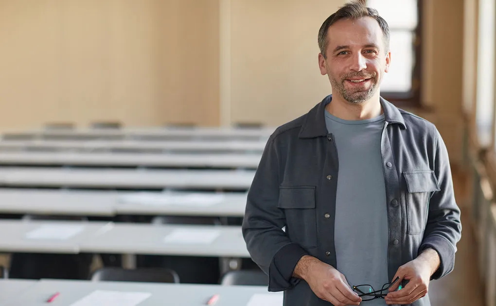 A teacher standing in a bright classroom