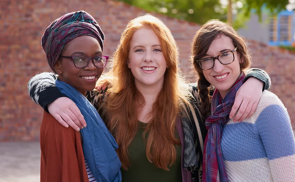 Three friends standing together outdoors